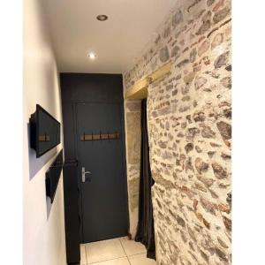 a door in a room with a stone wall at La table ronde in Vienne