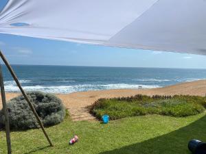 a view of the ocean from a beach under an umbrella at 3 bedroom house with magnificent ocean views in Hentiesbaai