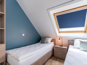 una piccola camera mansardata con due letti e una finestra di Apartment Green Garden-16 by Interhome a De Haan