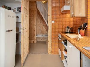 a kitchen with a white refrigerator and a staircase at Chalet Quinette by Interhome in Ovronnaz