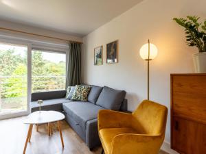 un soggiorno con un divano e una sedia di Apartment Green Garden-16 by Interhome a De Haan Altre 16 foto