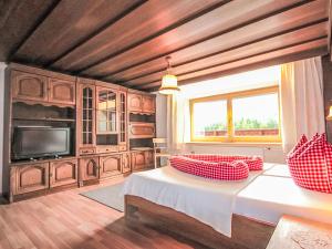 a living room with a bed and a television at Apartment Alpenfarm Poschhof by Interhome in Kaunerberg