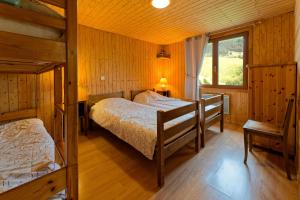 a bedroom with two bunk beds and a window at Chalet La Tournette in Montmin