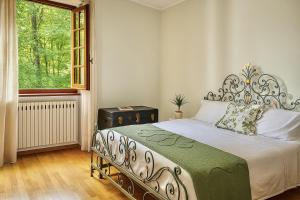 une chambre avec un grand lit avec une fenêtre dans l'établissement Villa Diana, à Castelnuovo di Garfagnana