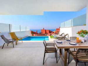 a patio with a table and chairs and a pool at Apartment Bayview Collection free Spa & Padel by Interhome in Torrox Costa +49 photos