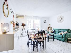 a living room with a table and a green couch at Apartment Atrium by Interhome in Caves