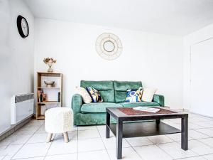 a living room with a green couch and a coffee table at Apartment Atrium by Interhome in Caves