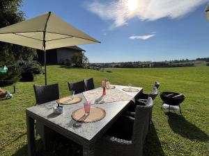 ein Tisch mit Stühlen und einem Sonnenschirm auf einem Feld in der Unterkunft Holiday Home Gustis Hüsli - Alpensicht & Natur pur by Interhome in Höchenschwand + 52 Fotos
