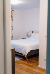 a bedroom with a bed with a white bedspread at Dimar Retreat Villa in Moisei