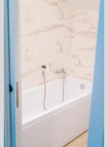 a bathtub in a bathroom with white marble walls at Dimar Retreat Villa in Moisei