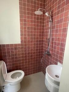 a red tiled bathroom with a toilet and a shower at Almaza Bay in Alexandria