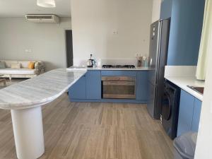 a kitchen with blue cabinets and a counter top at Almaza Bay in Alexandria