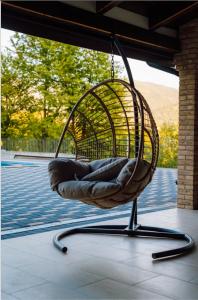 a rattan chair hanging from a porch at Dimar Retreat Villa in Moisei