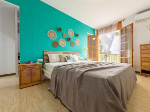una camera da letto con un letto grande e una parete blu di Holiday Home Corbella by Interhome a Sant Jaume d'Enveja