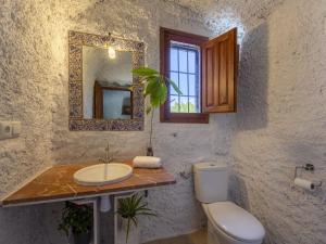 a bathroom with a sink and a toilet and a mirror at Holiday Home Cueva Mariana Pineda by Interhome in Terque