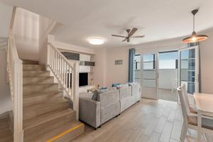 Una sala de estar con un sofá y una escalera. en Casa Melani, Sea and Relax, en Playa Honda