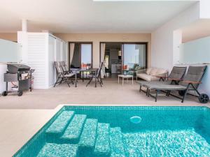 a swimming pool in a living room with a table and chairs at Apartment Heaven Free Spa & Padel by Interhome in Torrox Costa