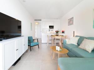 a living room with a blue couch and a table at Apartment Heaven Free Spa & Padel by Interhome in Torrox Costa +33 photos