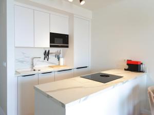 a kitchen with white cabinets and a counter top at Apartment Heaven Free Spa & Padel by Interhome in Torrox Costa