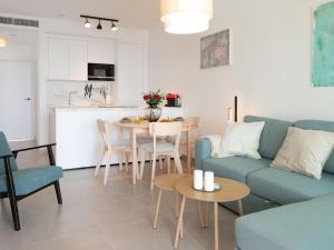 a living room with a blue couch and a table at Apartment Heaven Free Spa & Padel by Interhome in Torrox Costa +33 photos