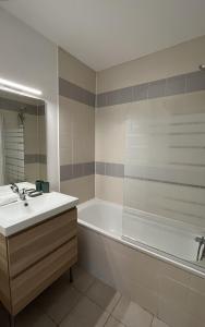 a bathroom with a tub and a sink and a bath tubermottermott at Les Maisons du Golf de la Cabre d'Or by Ateya Vacances in Cabriès