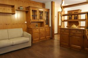 a living room with a couch and wooden cabinets at Sas da Rocia by go new location in Soraga
