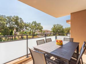 einen Tisch und Stühle auf dem Balkon eines Hauses in der Unterkunft Apartment Les Pins Parasols by Interhome in Bormes-les-Mimosas