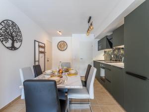 eine Küche und ein Esszimmer mit Tisch und Stühlen in der Unterkunft Apartment Les Pins Parasols by Interhome in Bormes-les-Mimosas