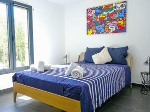 Un dormitorio con una cama con sábanas azules y blancas. en Apartment Foce Dell Edera-4 by Interhome, en Bonifacio