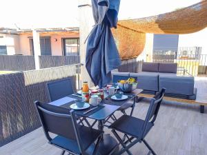 Una mesa y sillas en un patio con sombrilla. en Apartment Foce Dell Edera-4 by Interhome, en Bonifacio