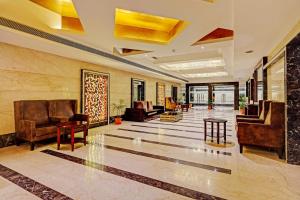 a lobby with leather chairs and tables in a building at Super Townhouse OAK Hotel City Mark Gurgaon in Gurgaon