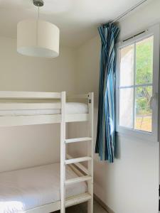 a bedroom with two bunk beds and a window at Les Maisons du Golf de la Cabre d'Or by Ateya Vacances in Cabriès