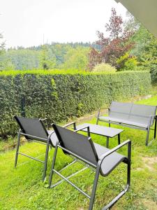 a couple of chairs and a table in the grass at Apartament w górach ze SPA in Szczyrk
