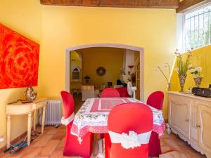 a dining room with a table and red chairs at Holiday Home Font Mourier by Interhome in Cogolin +28 photos