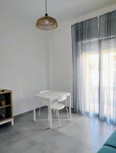 a white table and chair in a room with a window at Come a casa in Turi +8 photos