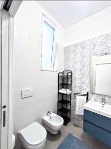 a white bathroom with a toilet and a sink at Come a casa in Turi