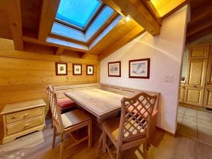 Un comedor con mesa y sillas de madera. en Gstaad Blue Sky Chalet with stunning views, en Gstaad