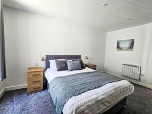 1 dormitorio con 1 cama grande y mesita de noche de madera en Apartment Fishertown Apartment 1st Floor by Interhome, en Nairn