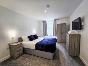 Un dormitorio con una cama grande y un televisor de pantalla plana. en Apartment Fishertown Apartment 1st Floor by Interhome, en Nairn