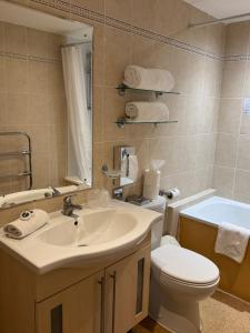 a bathroom with a sink and a toilet and a tub at Royal Hotel in Scarborough +54 photos