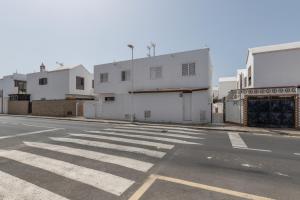 Una calle vacía con edificios blancos y un paso de peatones en Casa Melani, Sea and Relax, en Playa Honda
