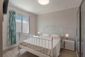 Habitación blanca con cuna y ventana en Casa Melani, Sea and Relax, en Playa Honda