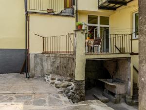 a building with a balcony and a table on a patio at Apartment Sabo by Interhome in Porlezza