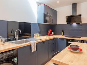 a kitchen with blue cabinets and a wooden table at Holiday Home Maison de ville by Interhome in Deauville