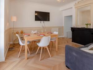 a living room with a wooden table and white chairs at Holiday Home Maison de ville by Interhome in Deauville