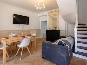 a living room with a dining room table and a couch at Holiday Home Maison de ville by Interhome in Deauville