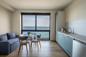 a kitchen and living room with a table and a couch at AER Apart & Wine in Eforie
