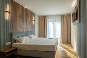 a bedroom with a bed and a large window at AER Apart & Wine in Eforie