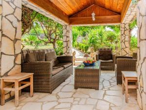 an outdoor patio with wicker furniture and a wooden ceiling at Holiday Home Gordana by Interhome in Maslenica