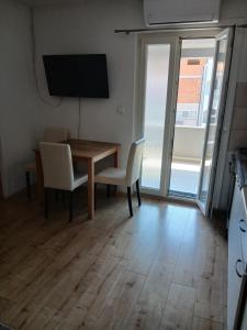 a dining room with a table and chairs and a television at Ž apartmani in Zadar